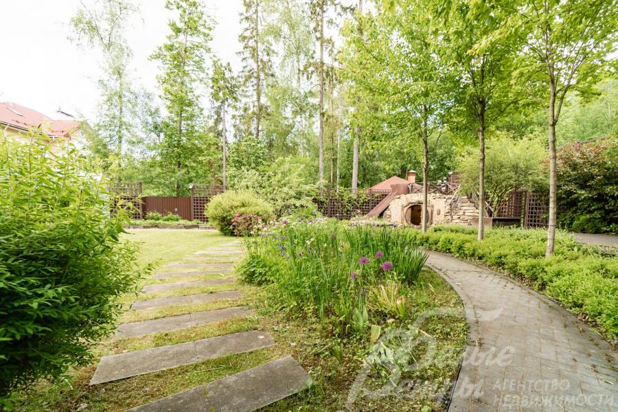 Дорожки и площадка возле дома вымощены гранитной плиткой