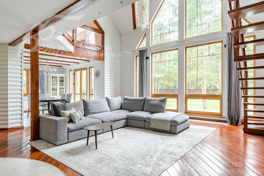 Двухсветная гостиная наполняет дом естественным светом. Огромные стекло-пакеты из лиственницы