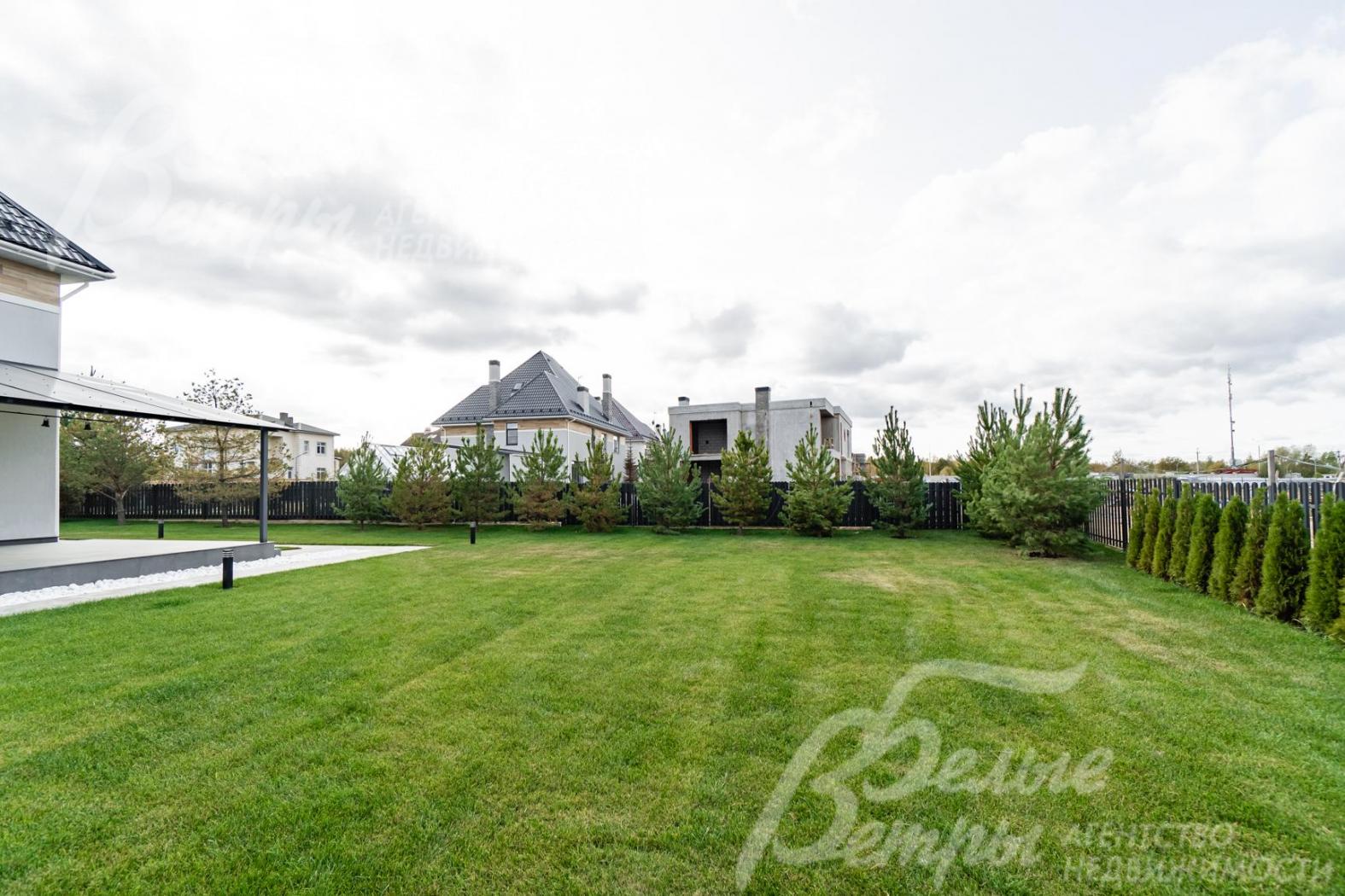 Участок с ландшафтом: высажены газон, туи и сосны