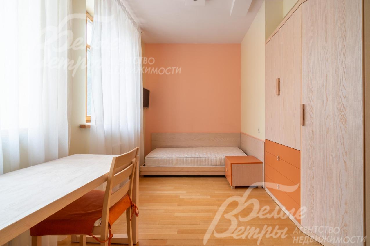 Одна из спален на первом этаже - с кроватью, рабочей зоной и вместительным шкафом