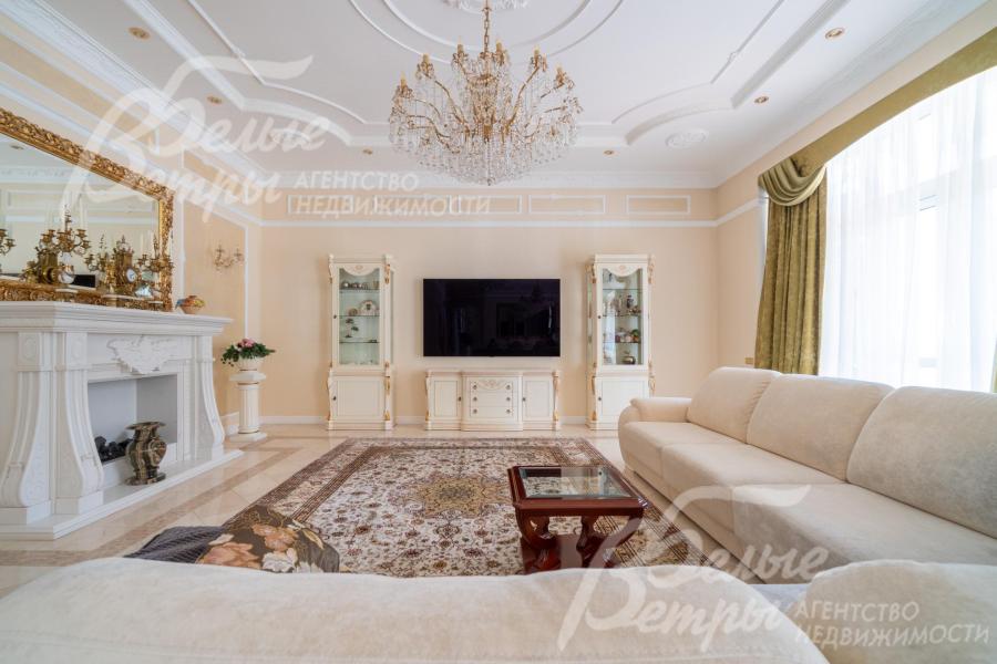 Зона гостиной. В ней установлен большой угловой диван с журнальным столиком, витринные шкафы, телевизор LG с диагональю 63 дюйма