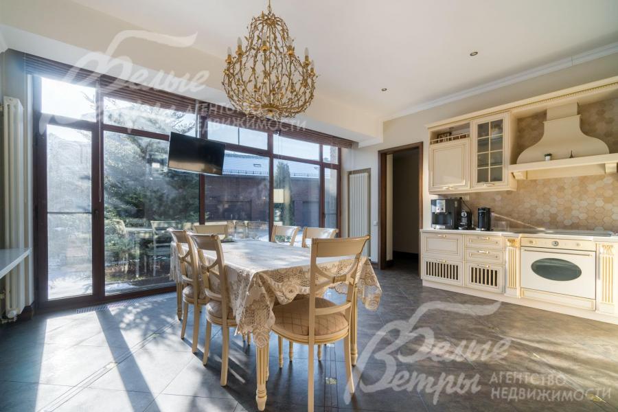 Светлая кухня с гарнитуром, встроенной техникой и обеденной группой на 6 персон