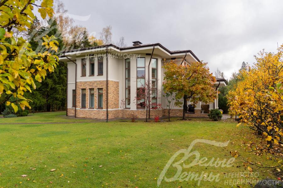 Дом стоит на просторном участке с ландшафтным дизайном в духе классического английского сада