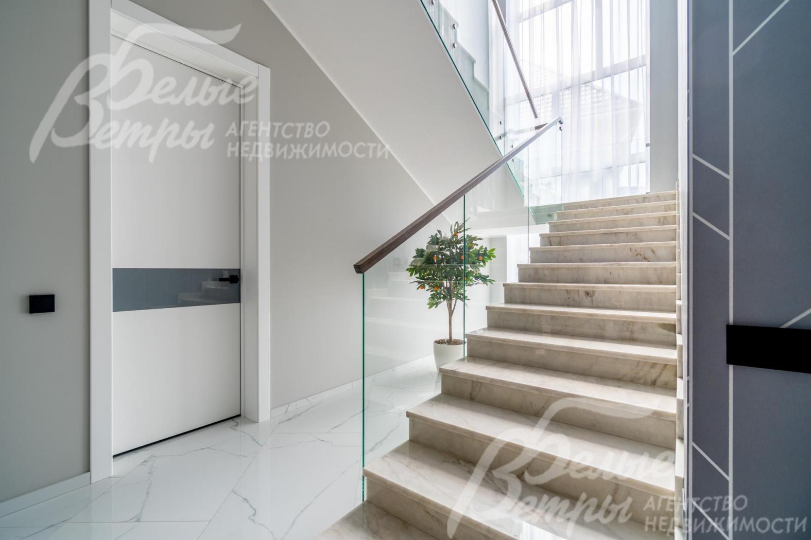 Ограждение лестницы - из закаленного стекла, поручни - дубовые