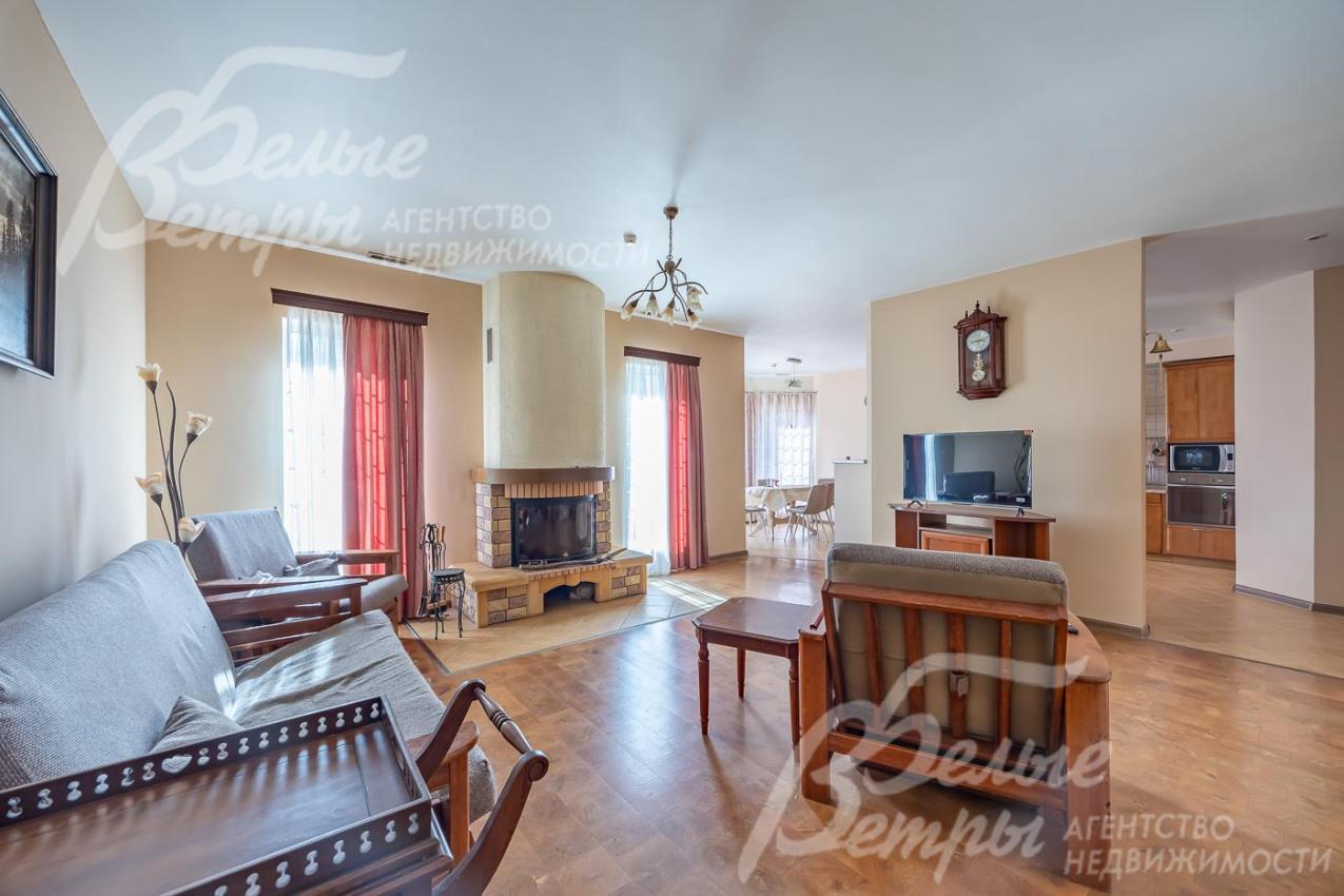 Гостиная с камином и панорамными окнами.