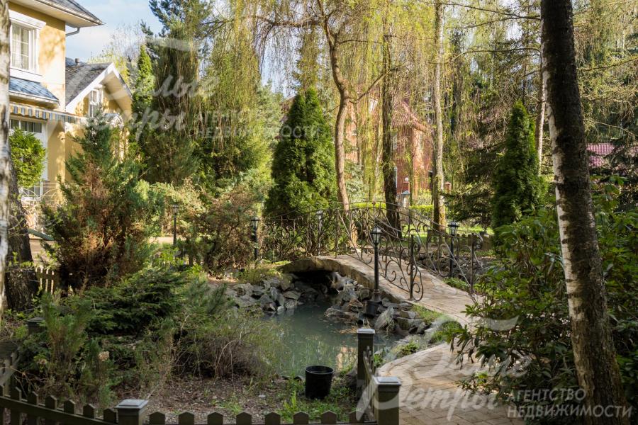 Участок украшает декоративный пруд с мостиком