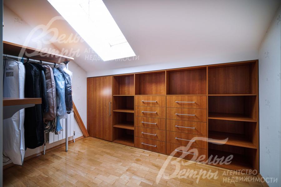 Гардеробная при спальне с системами хранения с солидным внешним видом