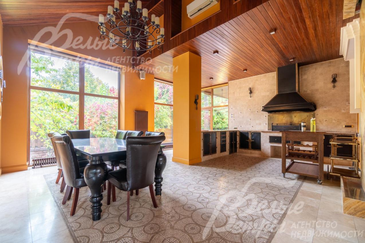 На тёплой террасе – обеденная группа, кухонная мебель, мангал с вытяжкой