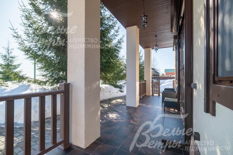 В основном доме - крытая терраса с садовой мебелью и живописным видом на участок