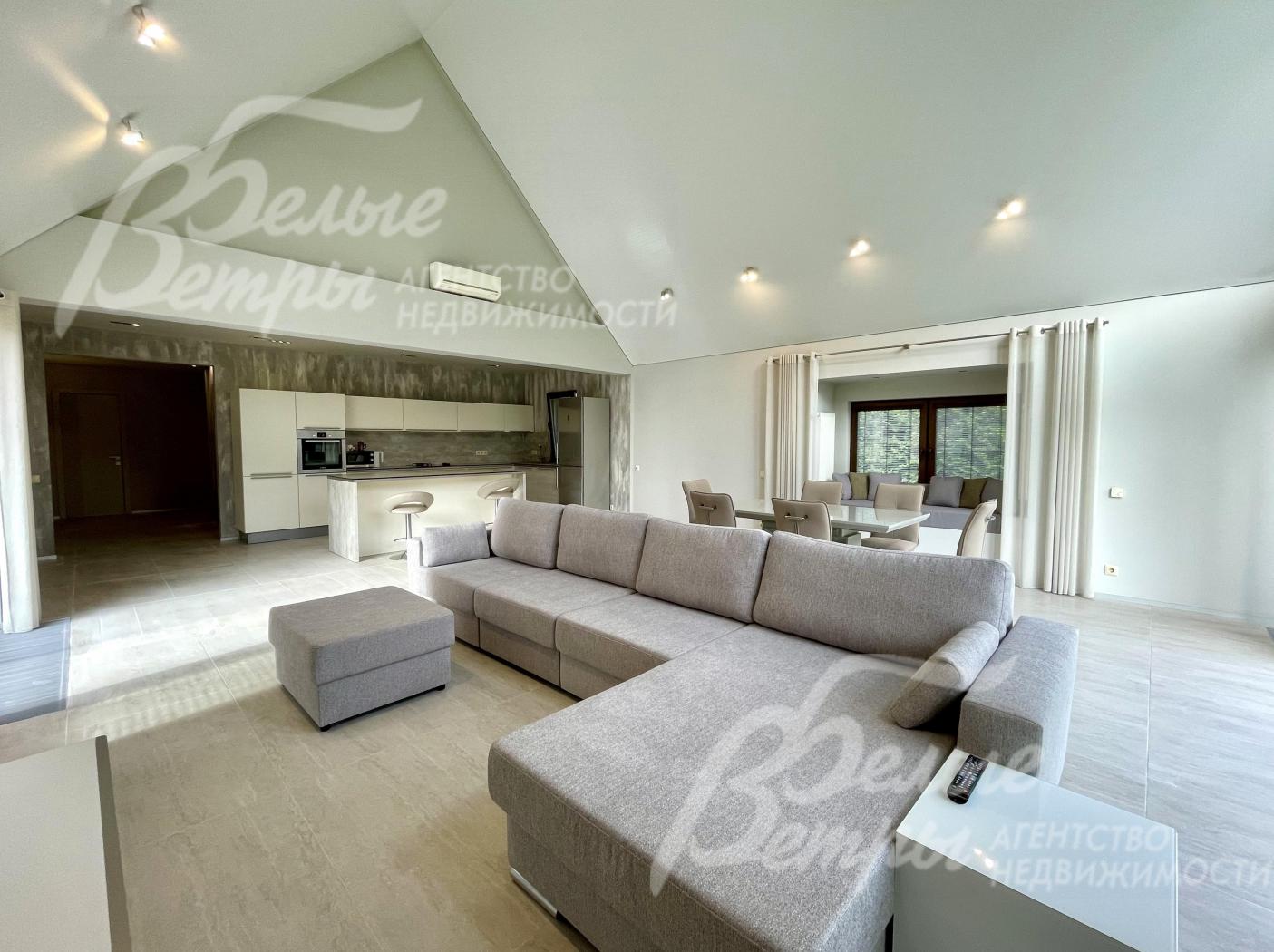 Светлая гостиная-столовая с панорамными окнами и высоким потолком