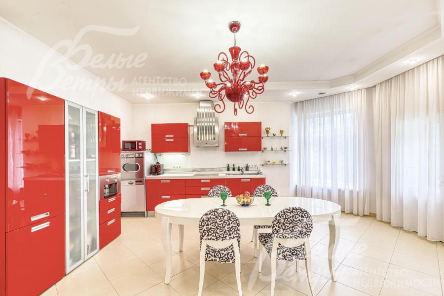 На кухне-столовой установлен контрастный гарнитур со встроенной бытовой техникой и обеденная группа