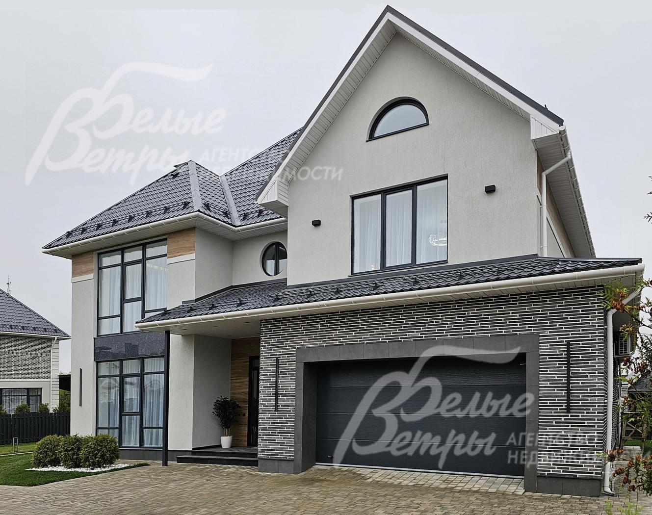 Элегантная внешняя отделка дома из колерованной штукатурки, плитки под кирпич и натурального гранита сочетается с панорамным остеклением