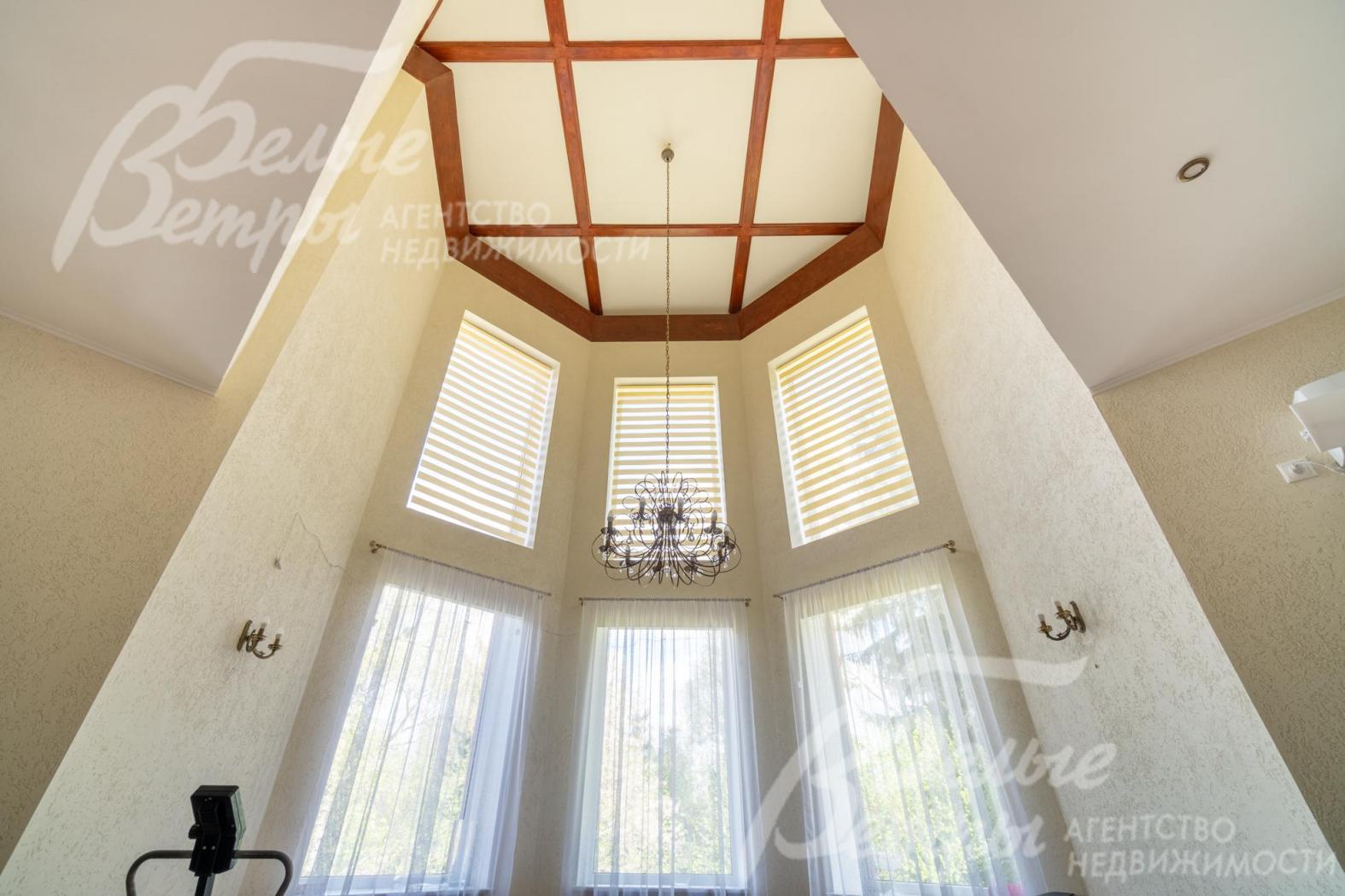 Гостиную украшают элегантные шторы и люстра