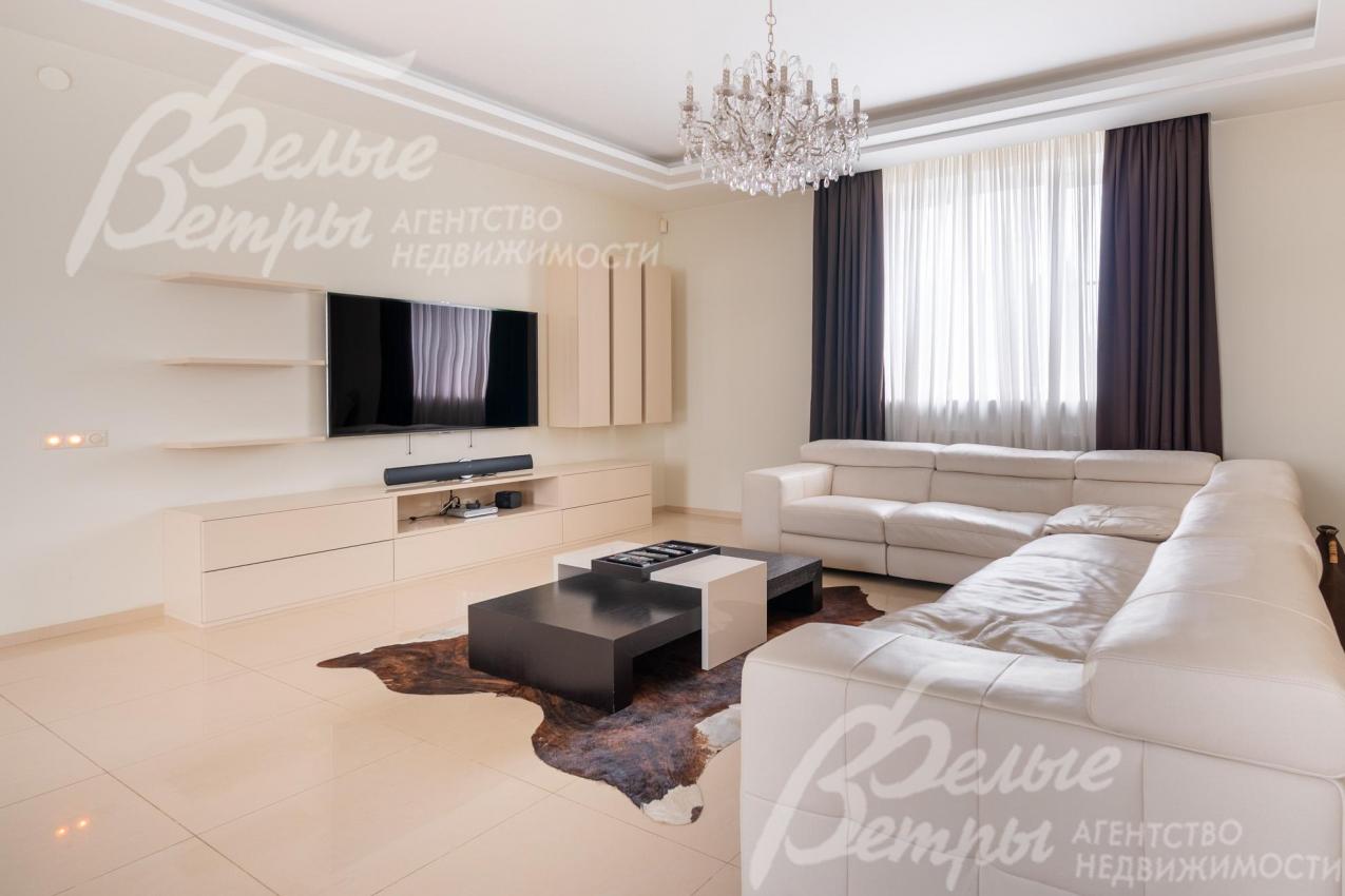 В гостиной - ТВ-зона и большой диван белого цвета премиум-сегмента