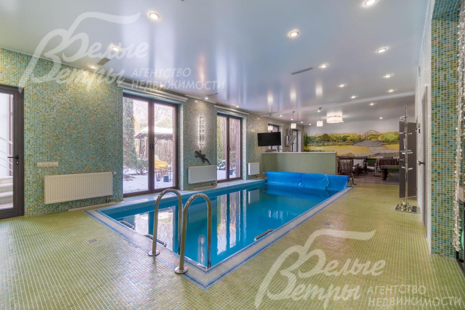 Большой бассейн в спа-зоне с окнами в пол и выходом на участок