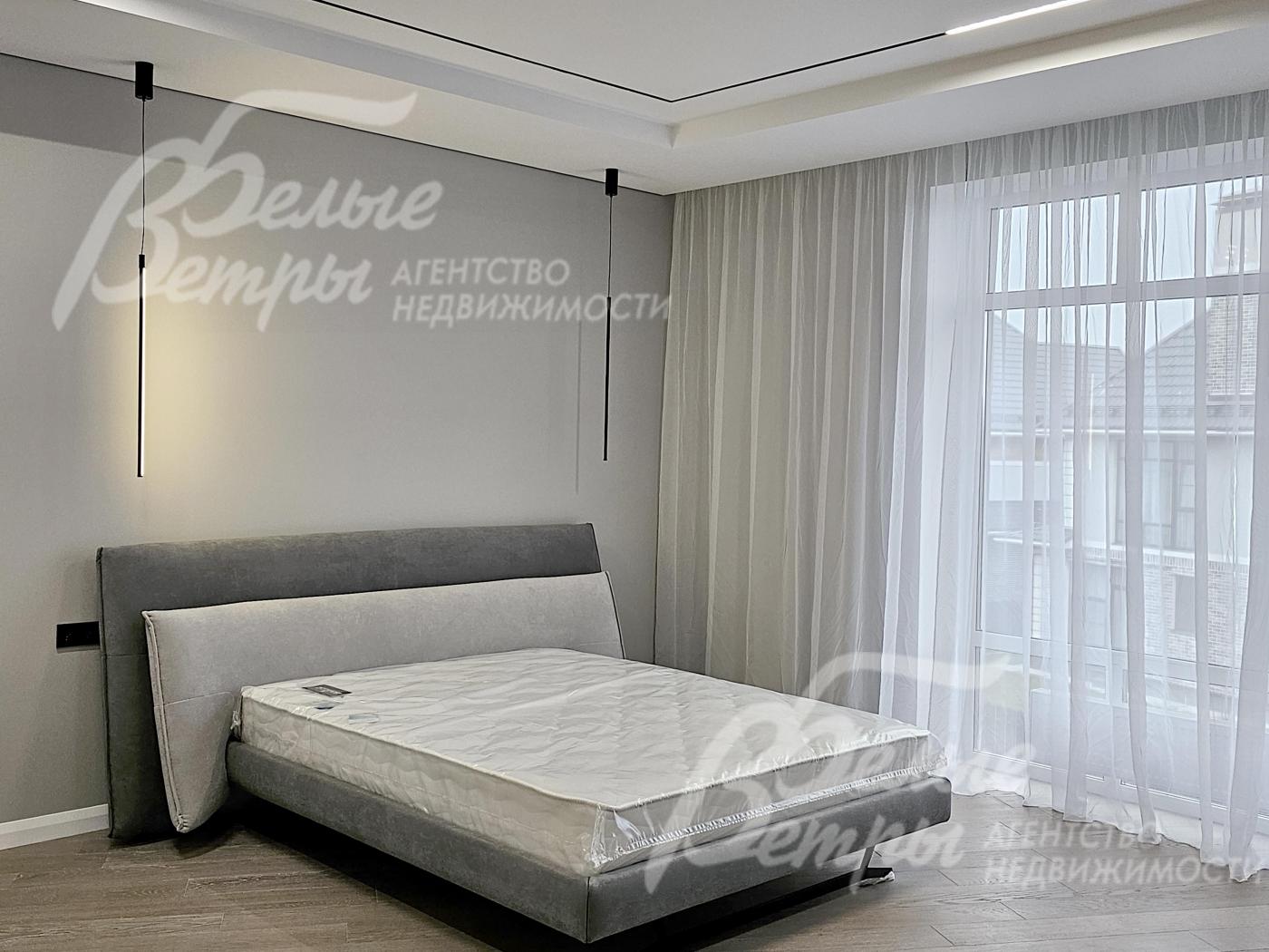 Мастер-спальня с панорамным окном, стены покрашены светло-серой краской