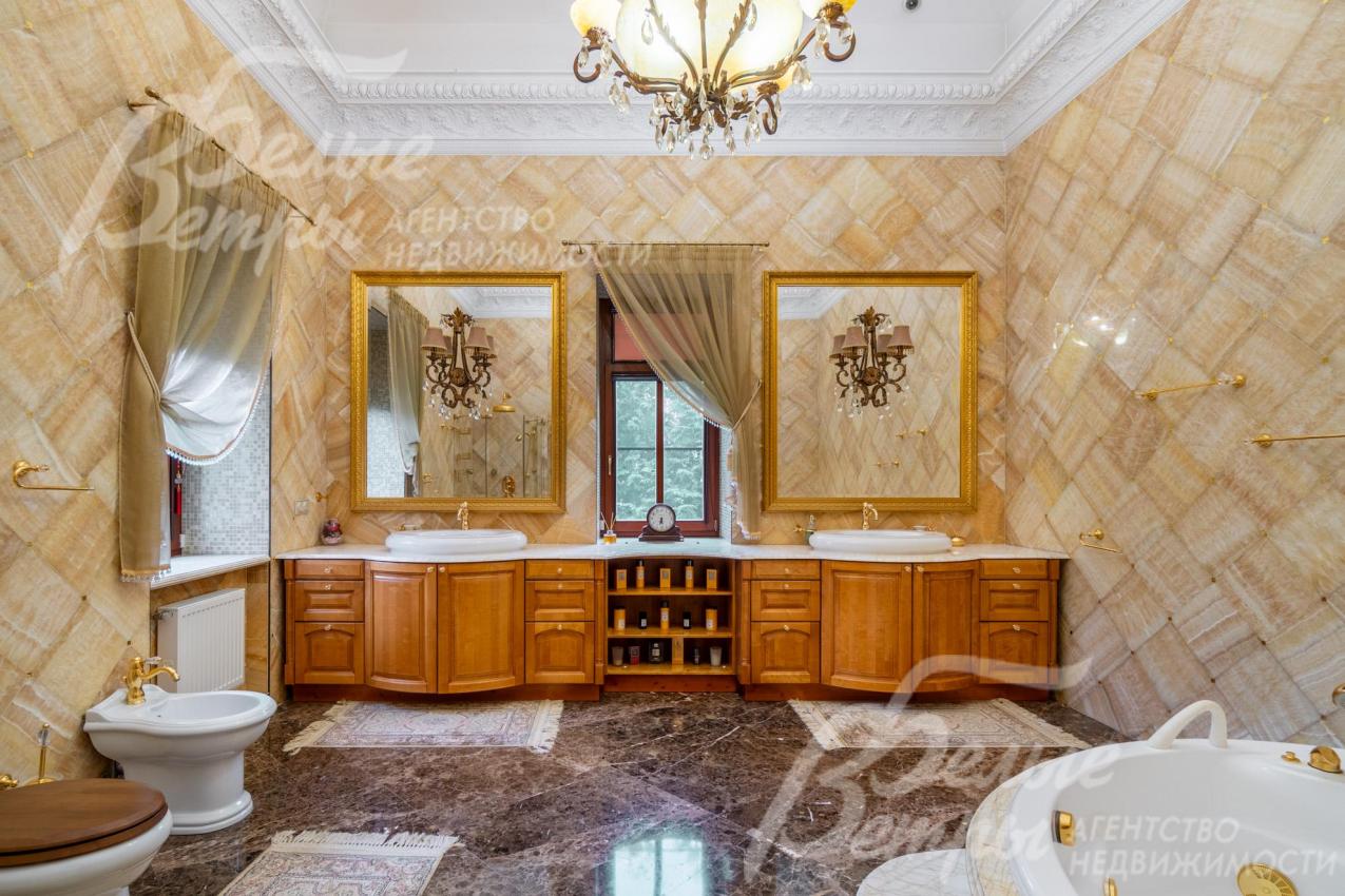 Санузел при мастер-спальне 25 кв.м с элитной сантехникой и мебелью, стены отделаны ониксом