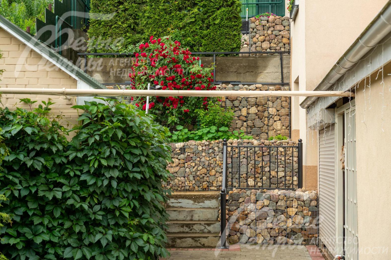 На участке - динамичная композиция зелёных насаждений с непрерывным цветением на протяжении всего сезона