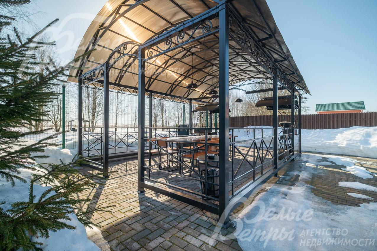 На участке стоит просторная крытая беседка-барбекю, внутри - два мангала, большой стол и мойка