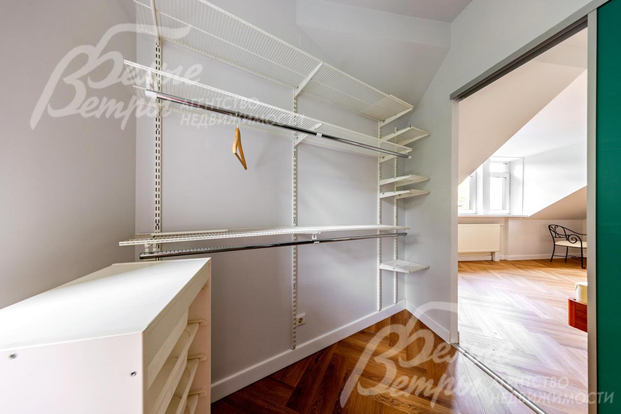 Гардеробная при спальне на втором этаже оснащена системой хранения