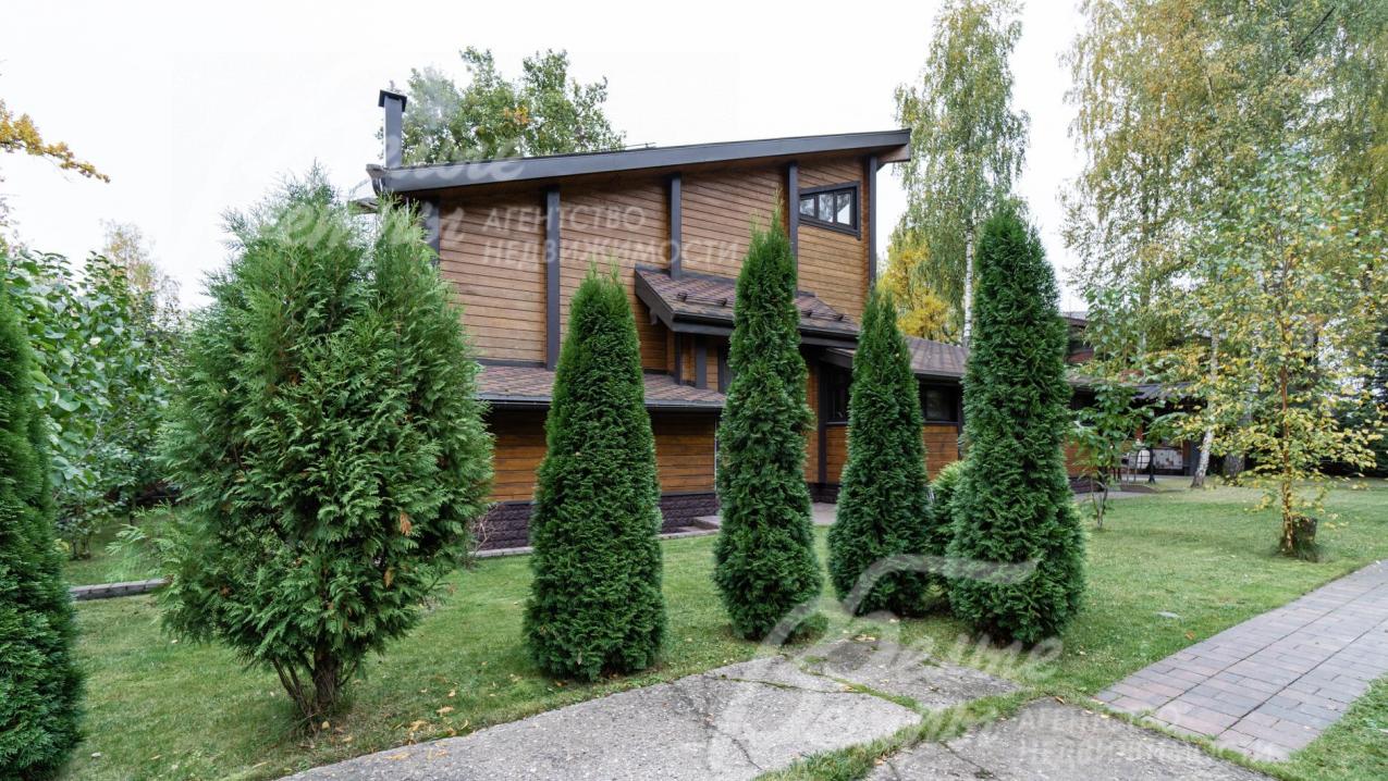 Участок с многочисленными декоративными деревьями и кустарниками (туи, сосны, ивы)