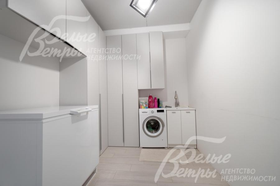 Постирочная на 1-м этаже оборудована стиральной машиной и системой хранения