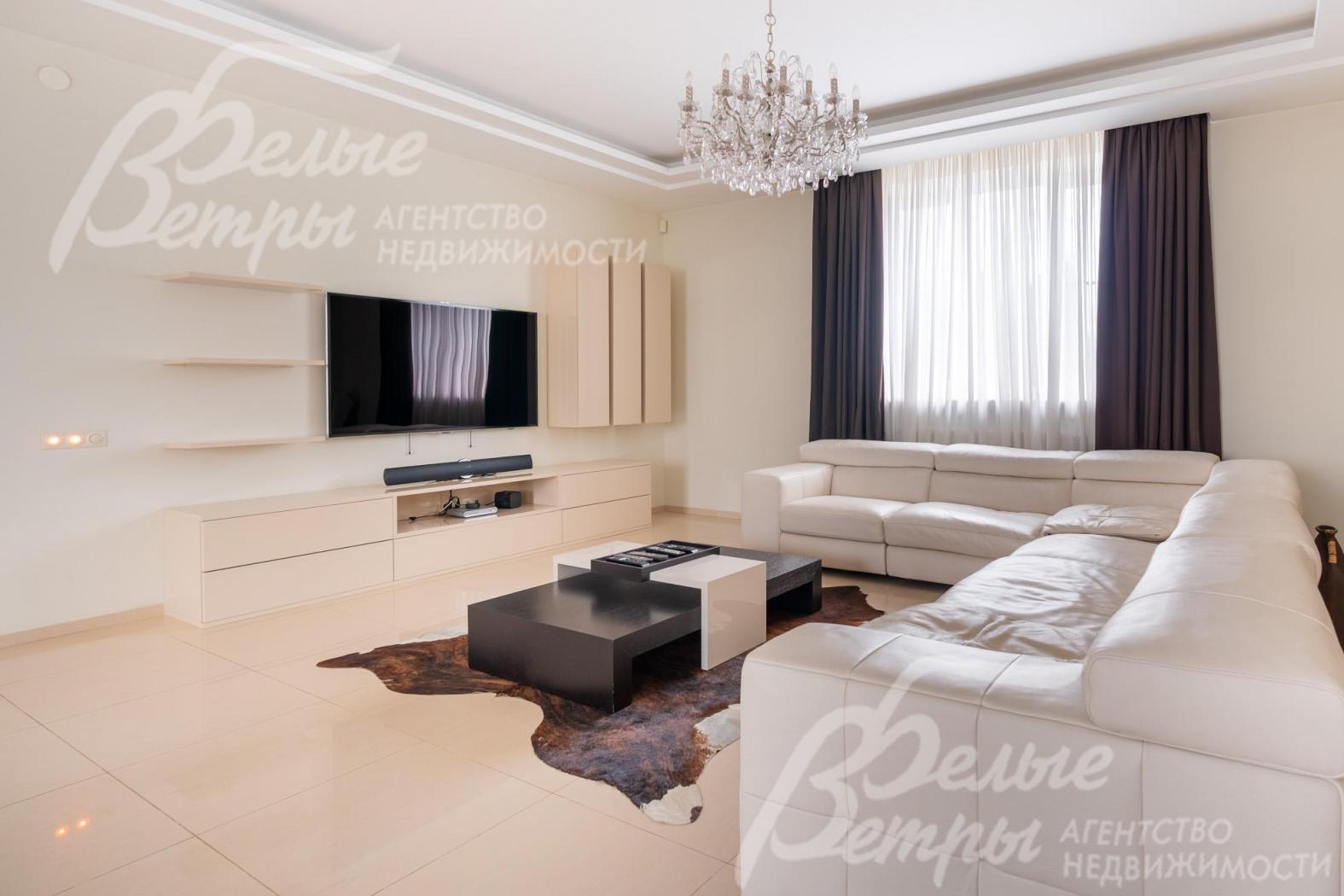 В гостиной - ТВ-зона и большой диван белого цвета премиум-сегмента