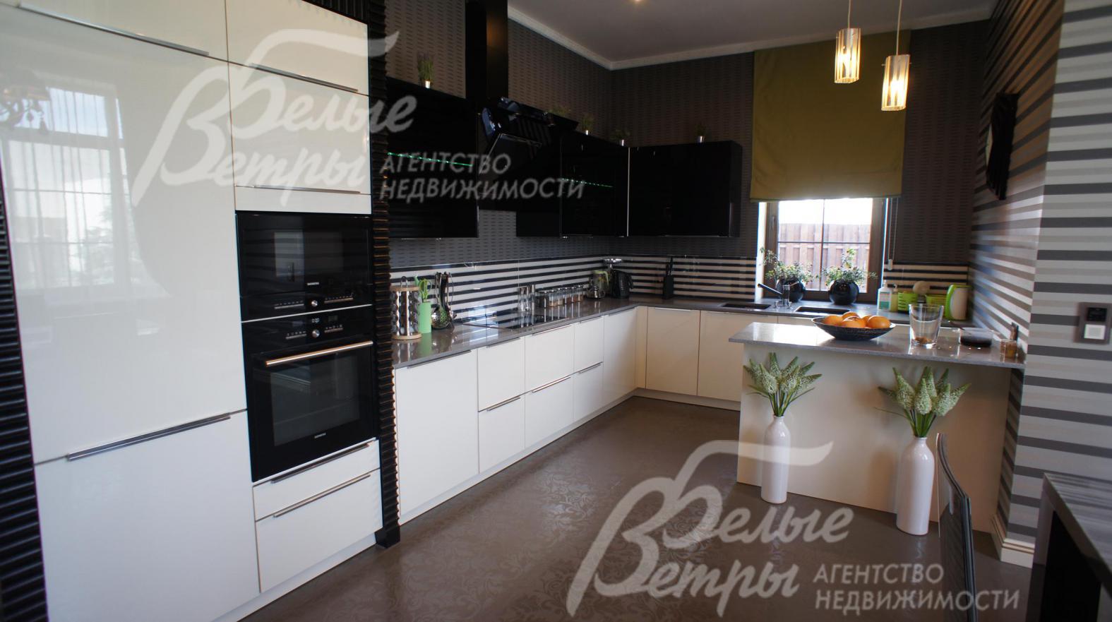 Модная кухня "HACKER" (Германия) со стеклянными сегментами, открывающимися на электроприводах, столешница - американский агломерированный камень.  Вытяжка "Кuppersbusch", встроенный холодильник "Liebherr", посудомойка "Bosch",  вся остальная техника "Siemens" 