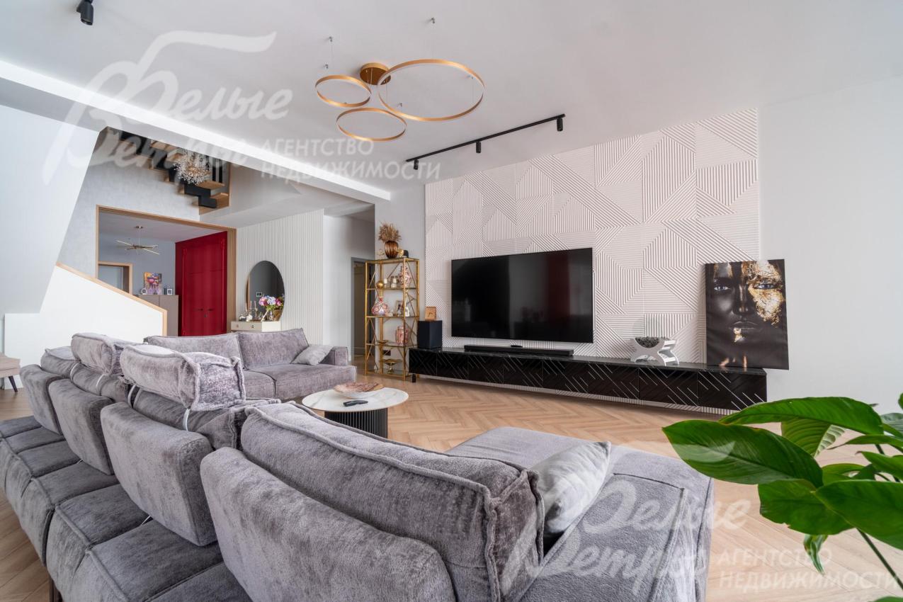 В гостиной установлен модульный диван с обивкой из ткани букле, телевизор LG 85 дюймов, консоль под ТВ, выполненная на заказ