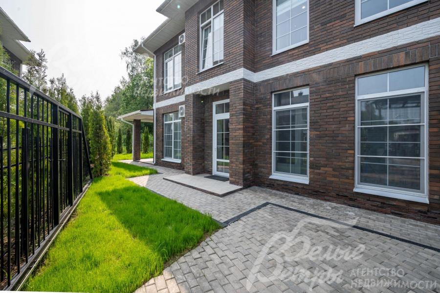 Благоустроенный участок огорожен металлическим забором.