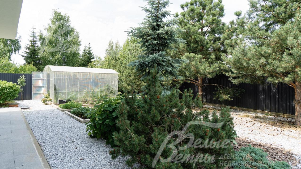 На участке выполнен ландшафтный дизайн в современном стиле по мотивам американского заднего двора