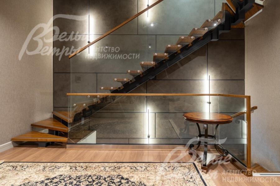 Холл второго этажа с прозрачным ограждением продолжается библиотекой