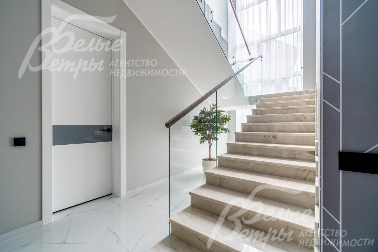 Ограждение лестницы - из закаленного стекла, поручни - дубовые