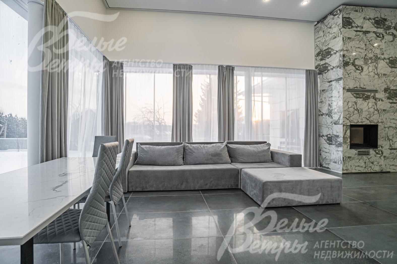 В гостиной панорамные окна, из которых открывается чудесный вид на участок и окрестности. 