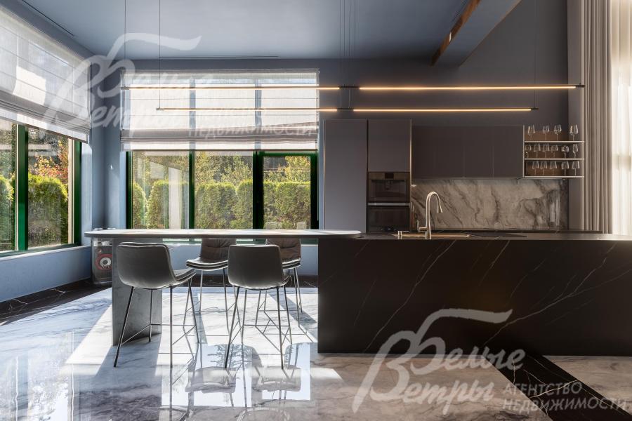 В кухонной зоне установлен пятиметровый остров — он плавно переходит в полубарный стол со стульями