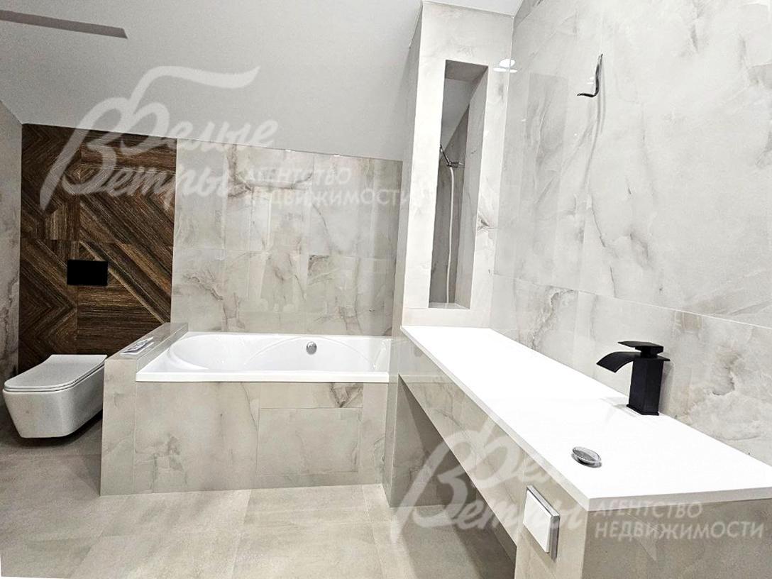 Санузел на втором этаже отделан керамогранитом "под белый мрамор", есть ванная и душевая