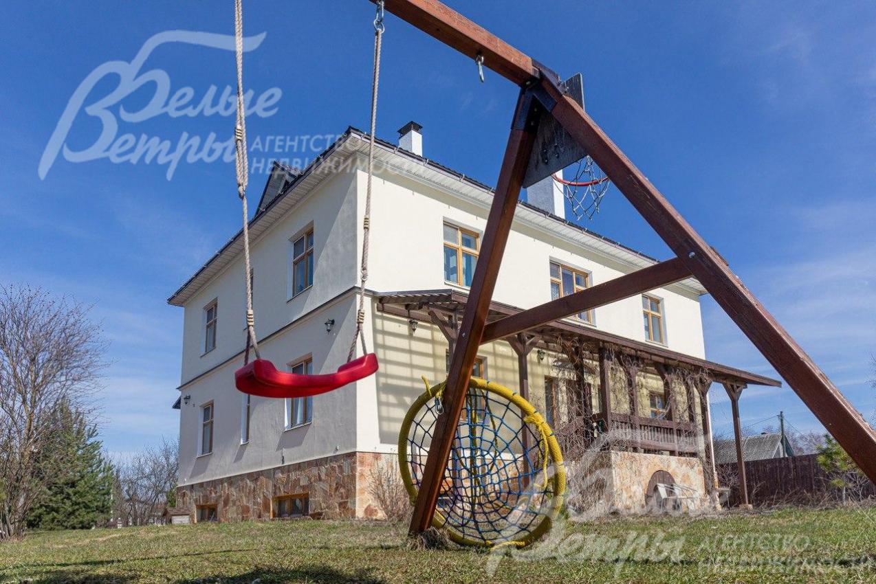 На участке детские качели и зона барбекю с лавочками.