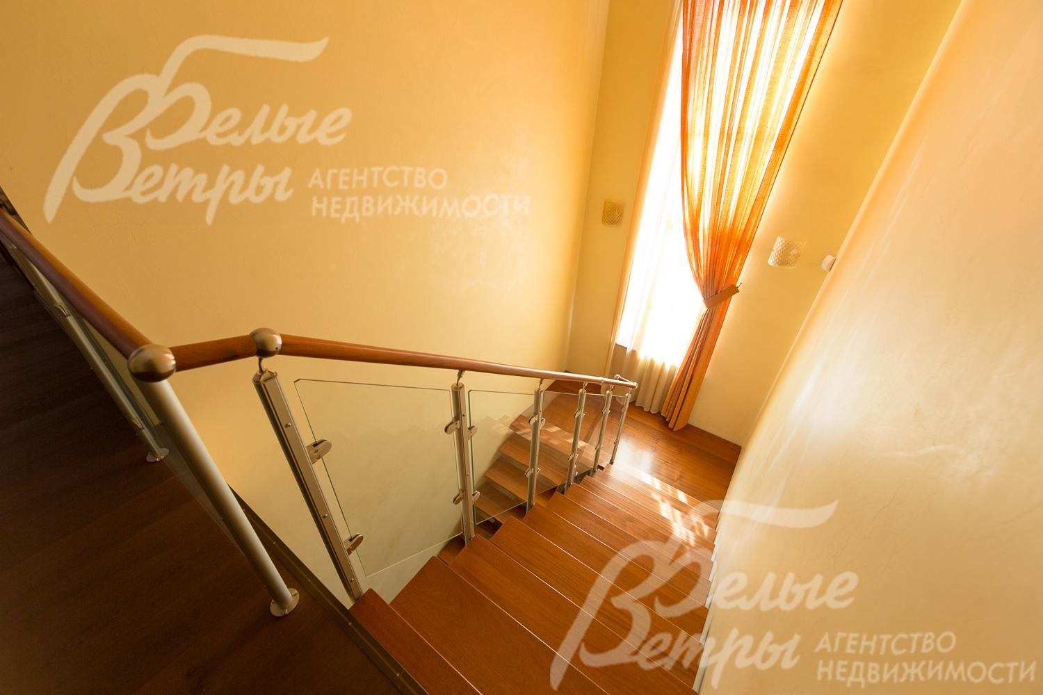 Деревянная лестница из красного дерева на металлическом каркасе. Ограждение - стекло триплекс