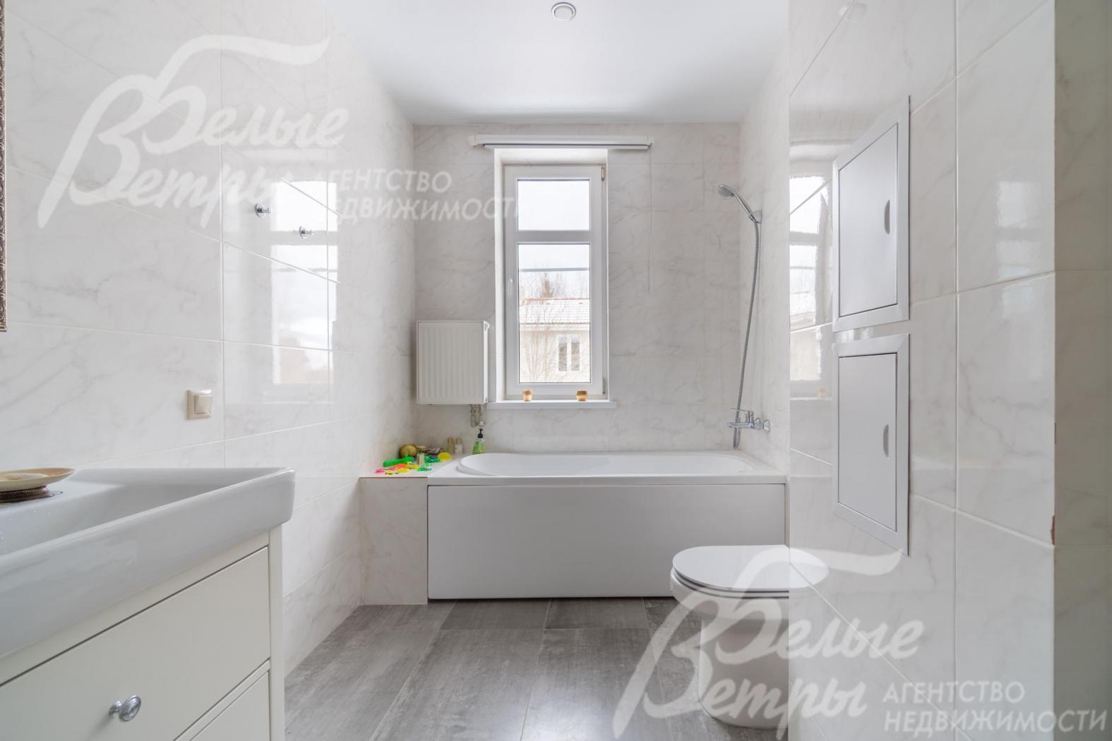 Просторный санузел с отделкой под белый мрамор