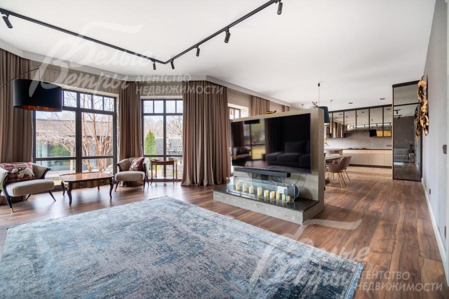 На отдельной акцентной стене в гостиной расположен широкоформатный телевизор и биокамин