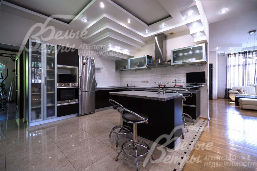 Кухня-столовая с разделением зон напольным покрытием и многоуровневыми потолками из гипсокартона